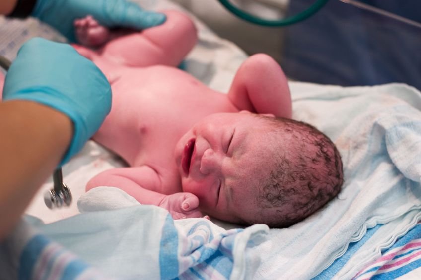 2059960 – newborn baby being examined in delivery room